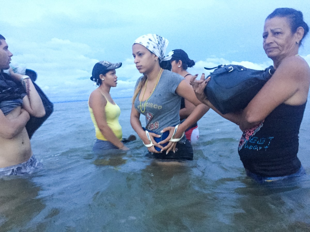 Liset and Marta, with locals who help guide migrants, prepare to board a boat at dawn on June 6, traveling from NecoclÃ­ to CapurganÃ¡, in Colombia, as they close in on Panamaâs border.