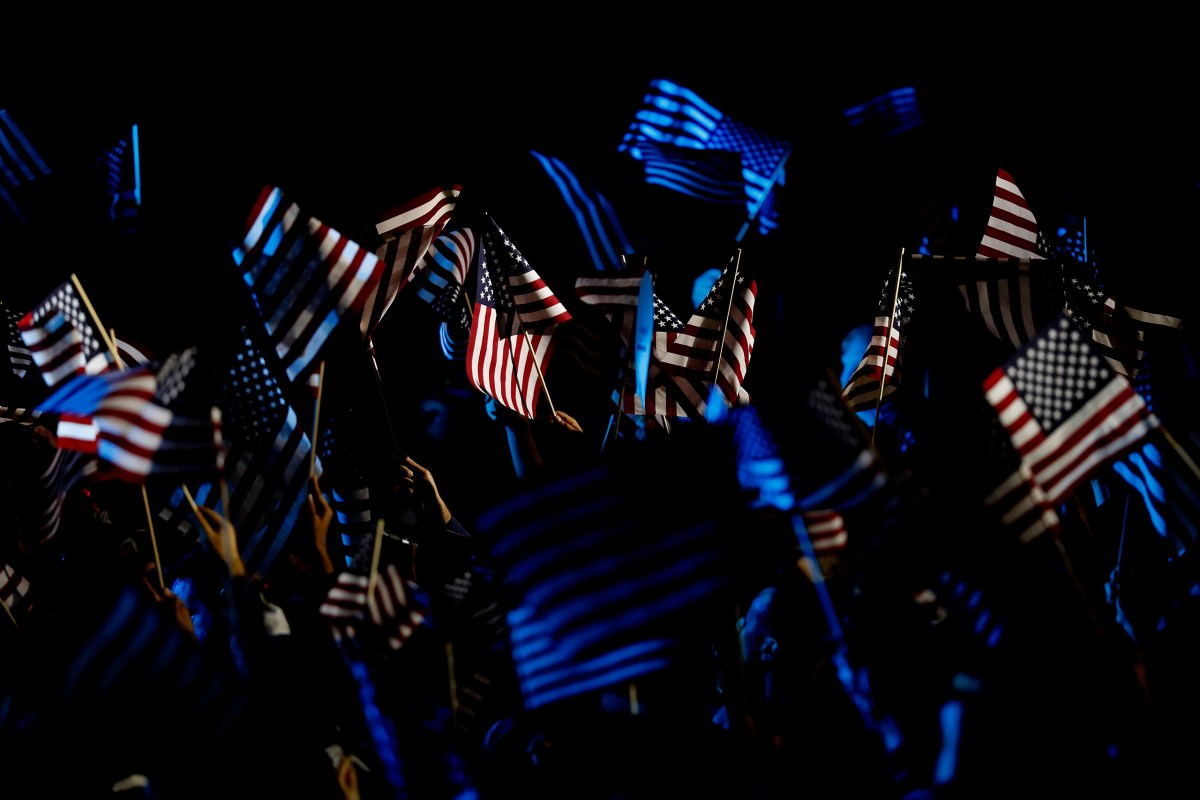 People wave American flags as they watch voting results be reported outside of Hillary Clinton's election night event at the Jacob K. Javits Convention Center, on Nov. 8, 2016, in New York City.