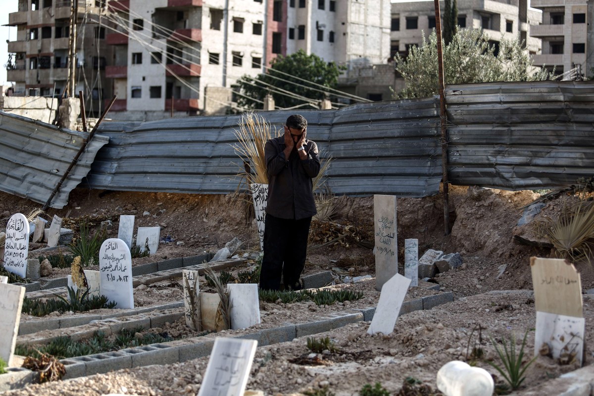 Abu Omar al-Ghoosh, who reportedly lost 17 relatives in a chemical attack, prays at a cemetery in Zamalka on Aug. 21. Mohammed BadraÃ¢ÂÂEPA