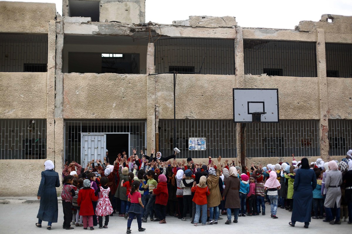 Children gather at a schoolyard in Douma on April 12, after a ceasefire in February allowed many students to return to school. Mohammed BadraÃ¢ÂÂEPA