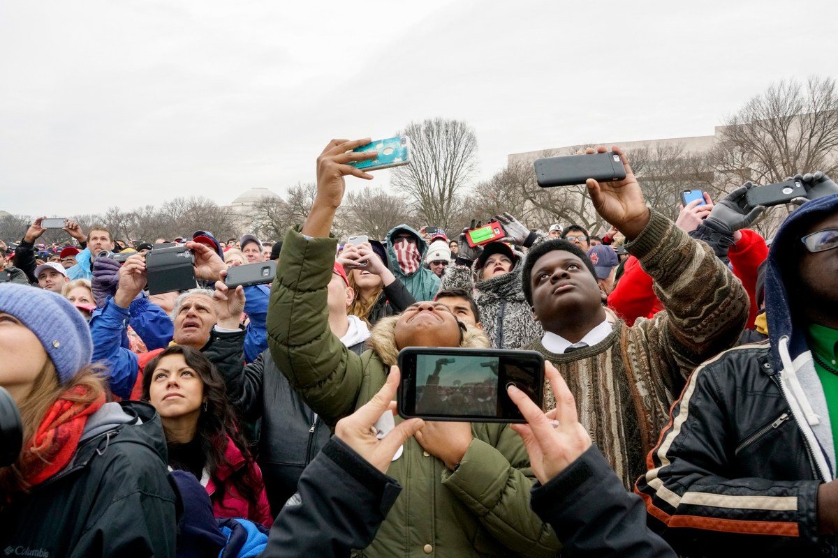 A woman who just got a glimpse of former First Lady Michelle Obama on a giant television screen reacts in a crowd of attendees during President Donald Trump's inauguration ceremony in Washington, D.C., on Jan. 20, 2017.