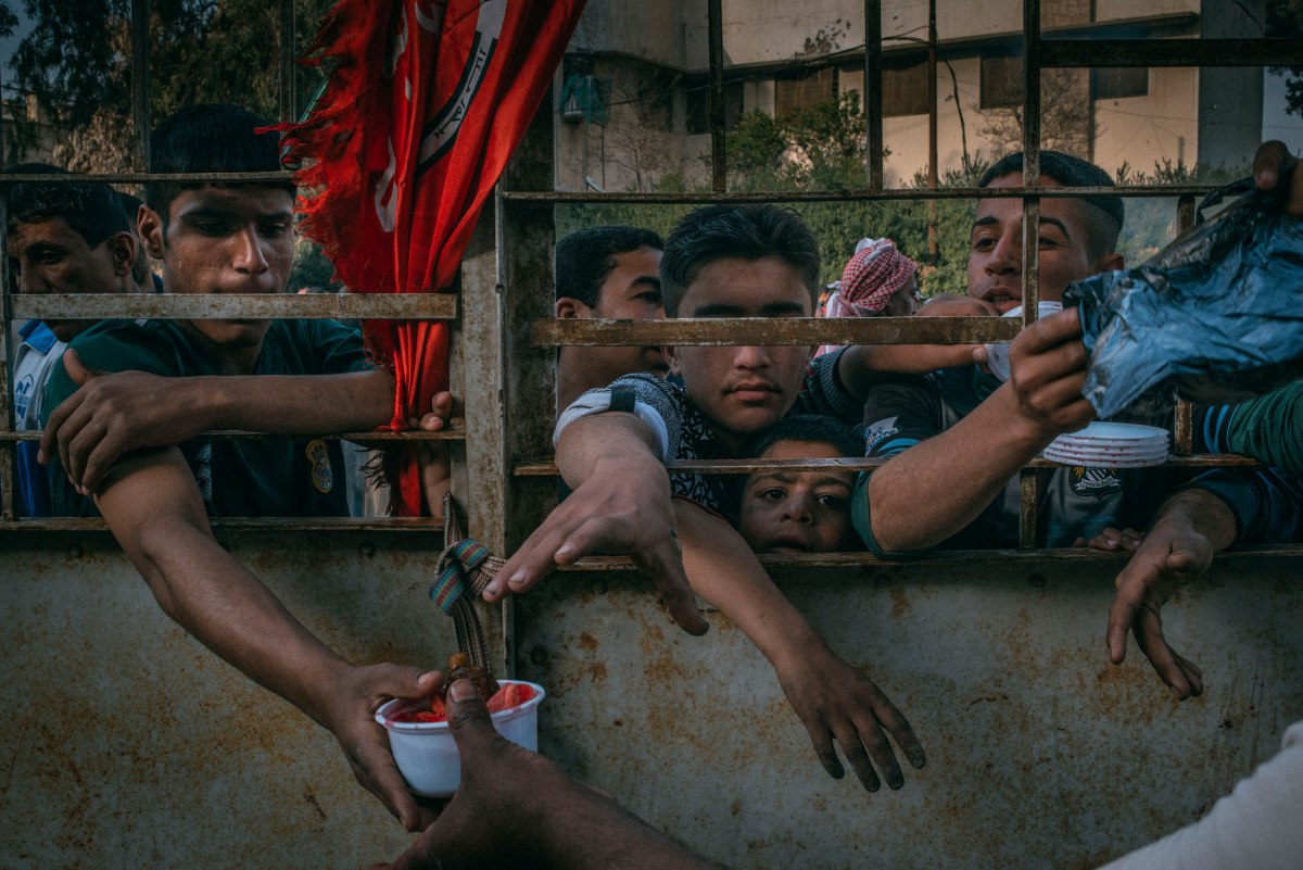 Iraqis wait for food distribution in Mosulâs Aqeedat neighborhood on March 29.