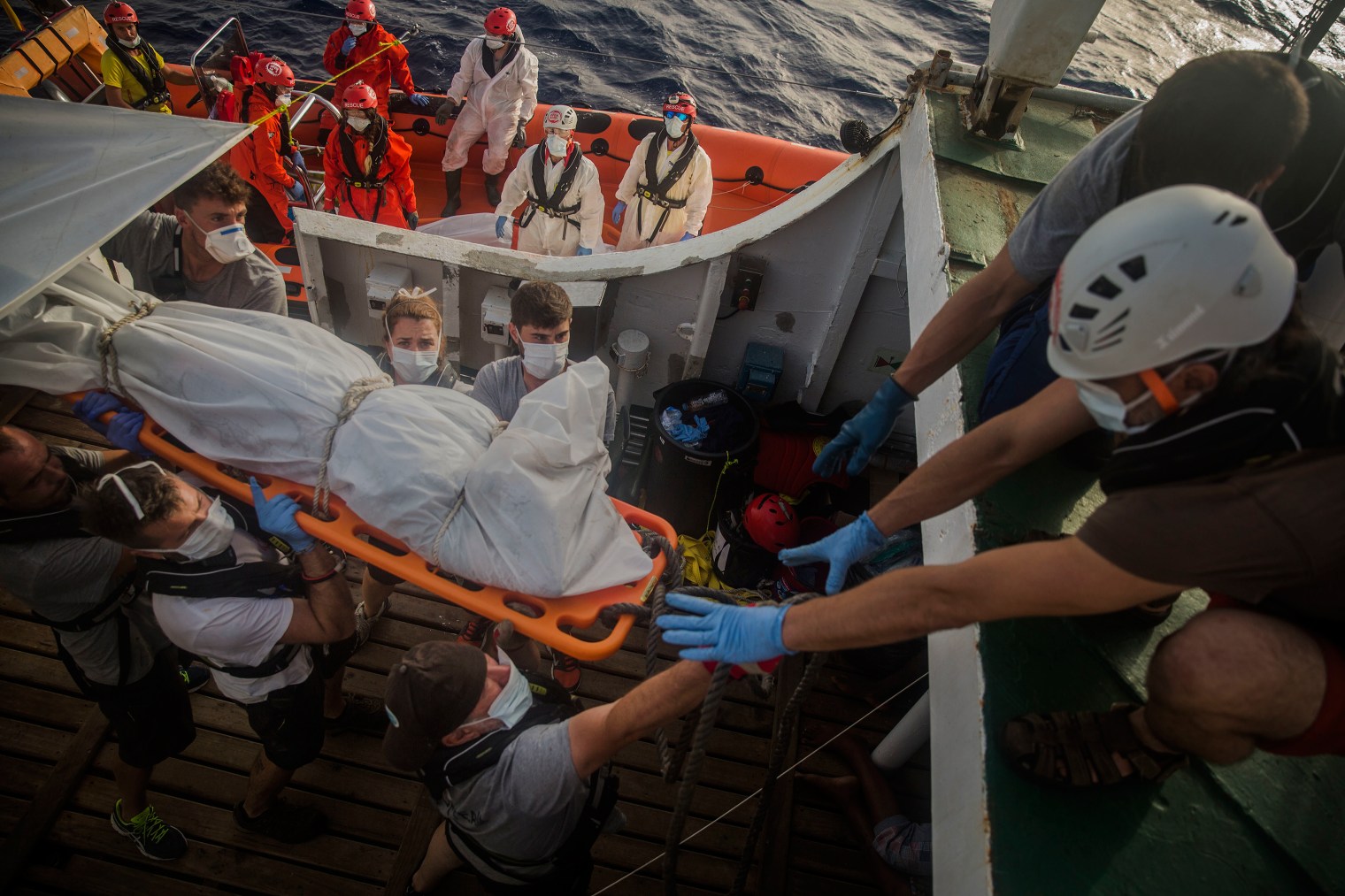 The body of a dead migrant is transferred from the rubber boat to the Open Arms vessel.