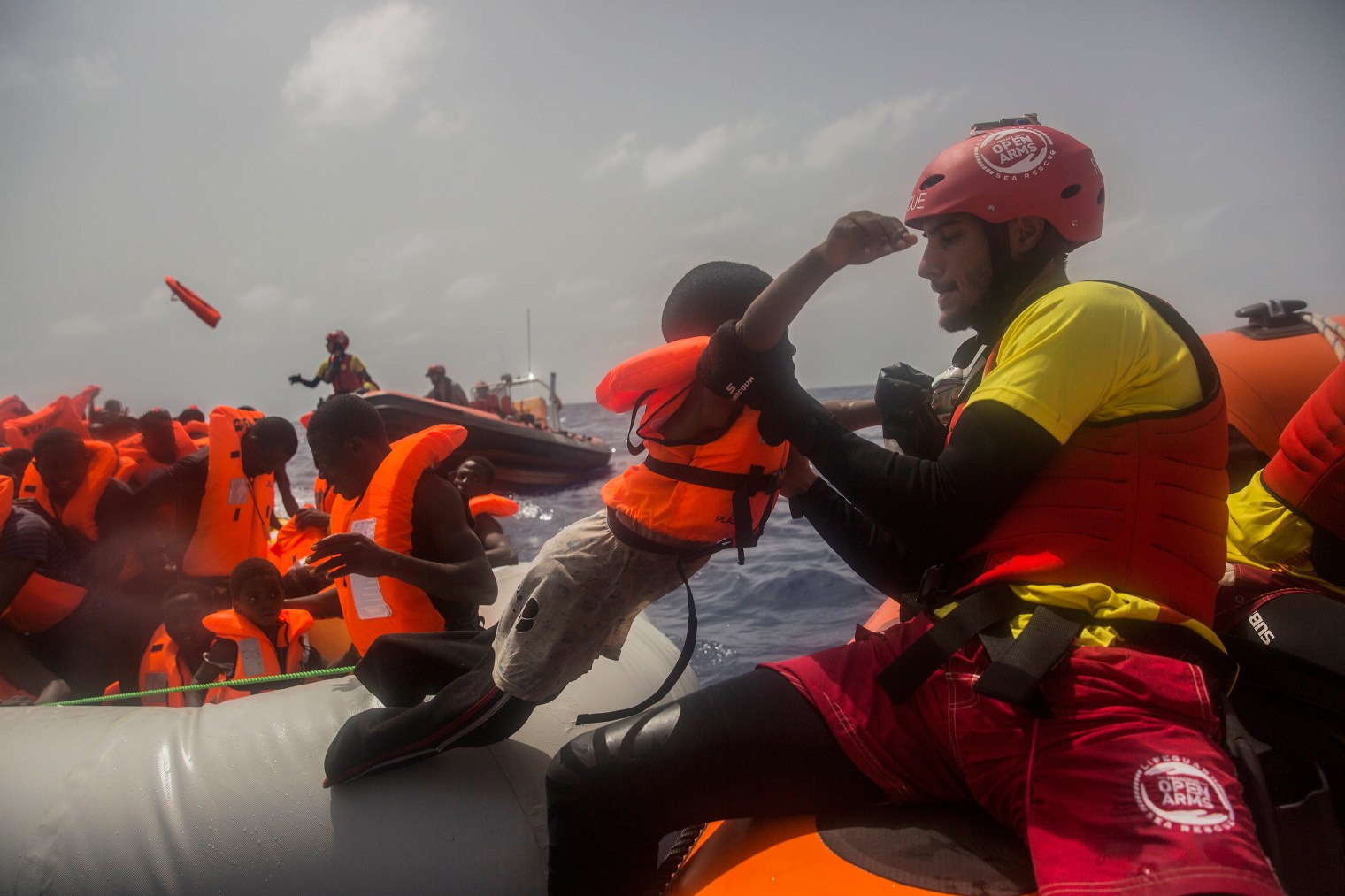 A child is helped by an aid worker during the rescue.