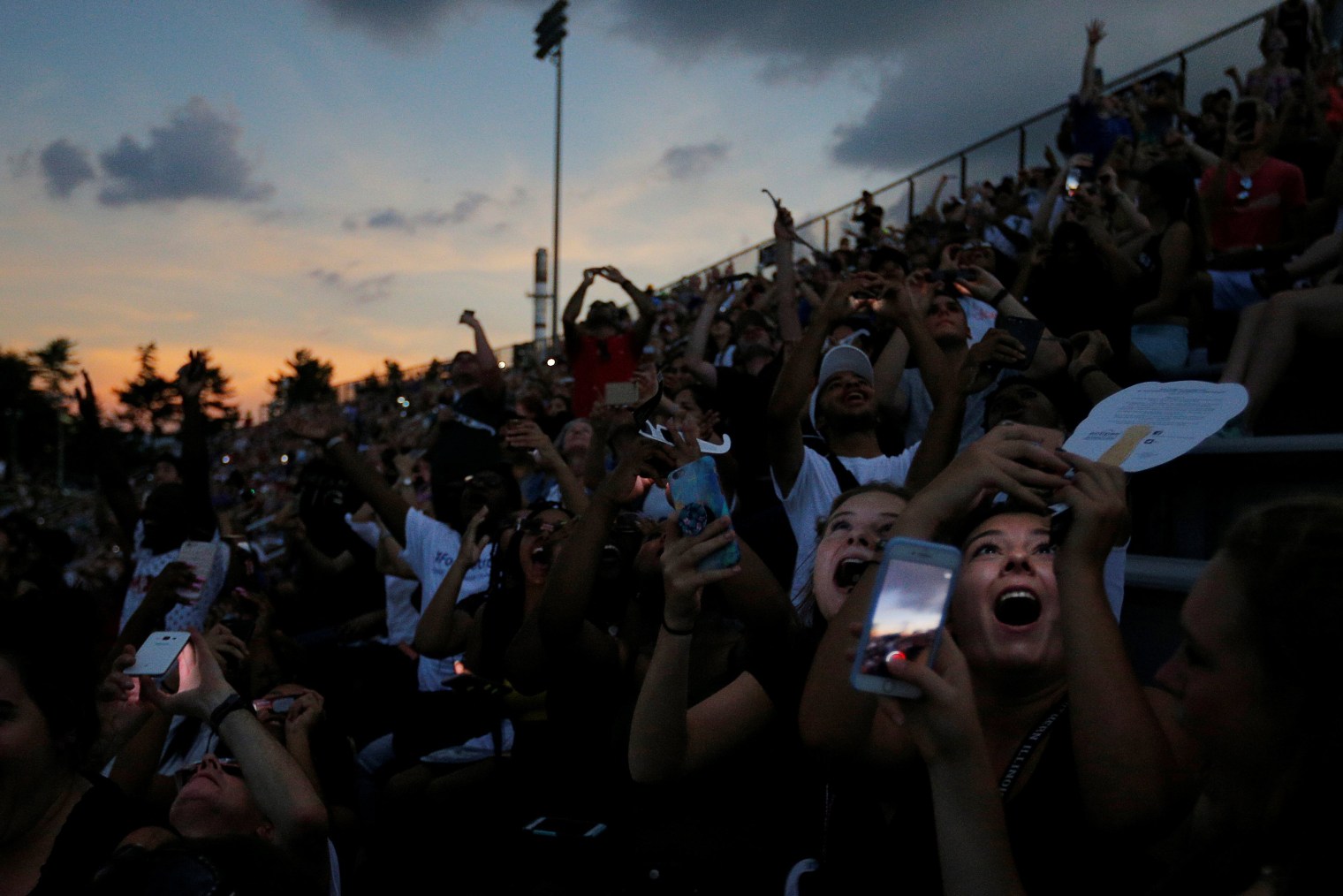 People react to the total eclipse in the football stadium at Southern Illinois University in Carbondale, Illinois, on Aug. 21, 2017.