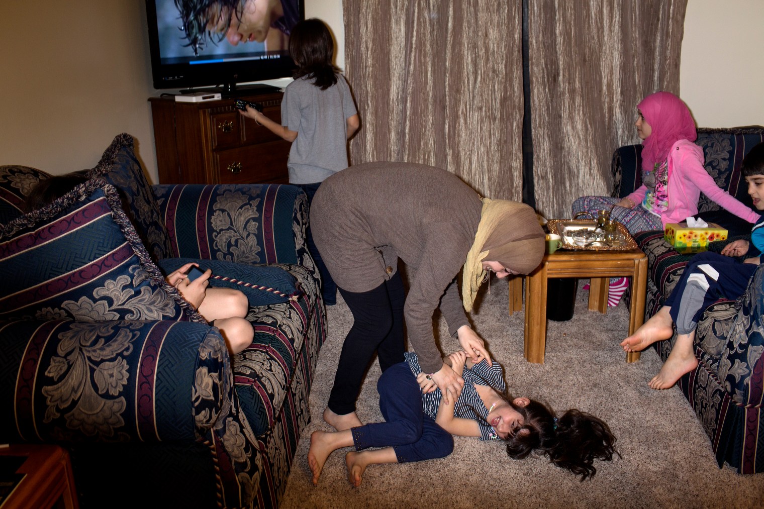 Ghazweh Aljabooli plays with her daughter Hala at the family's new apartment in West Des Moines, Iowa.