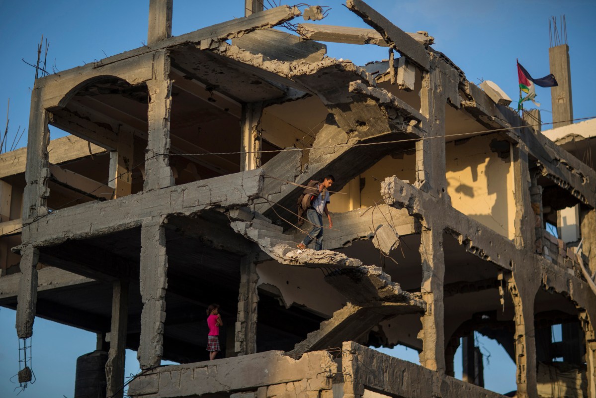 Ahmed Atawna going down at the stairs of their demolished house in Al-Shaaf area. The family live in a tent near the damaged house. in the east of Gaza on, 01 July 2015. By Wissam Nassar.