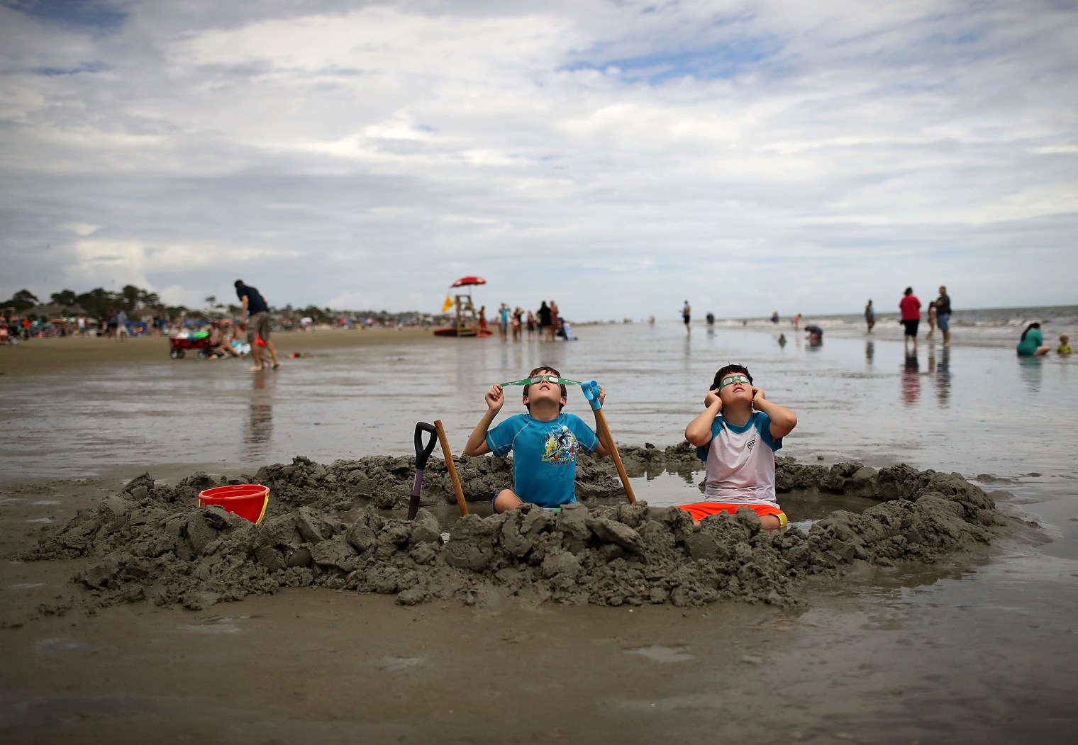 Chris and Gabe Fabiano, who are brothers, watch the first solar eclipse to sweep across the United States in over 99 years on the beach in Hilton Head, S.C., on Aug. 21, 2017.