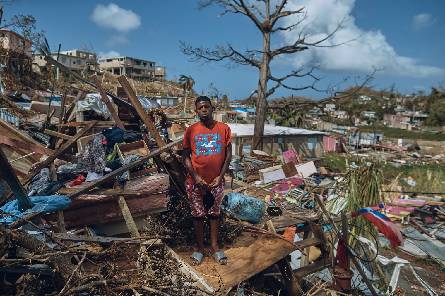 A man makes a fire in between damaged houses after sunset in San Isidro, Puerto Rico, on Sept. 28, 2017.