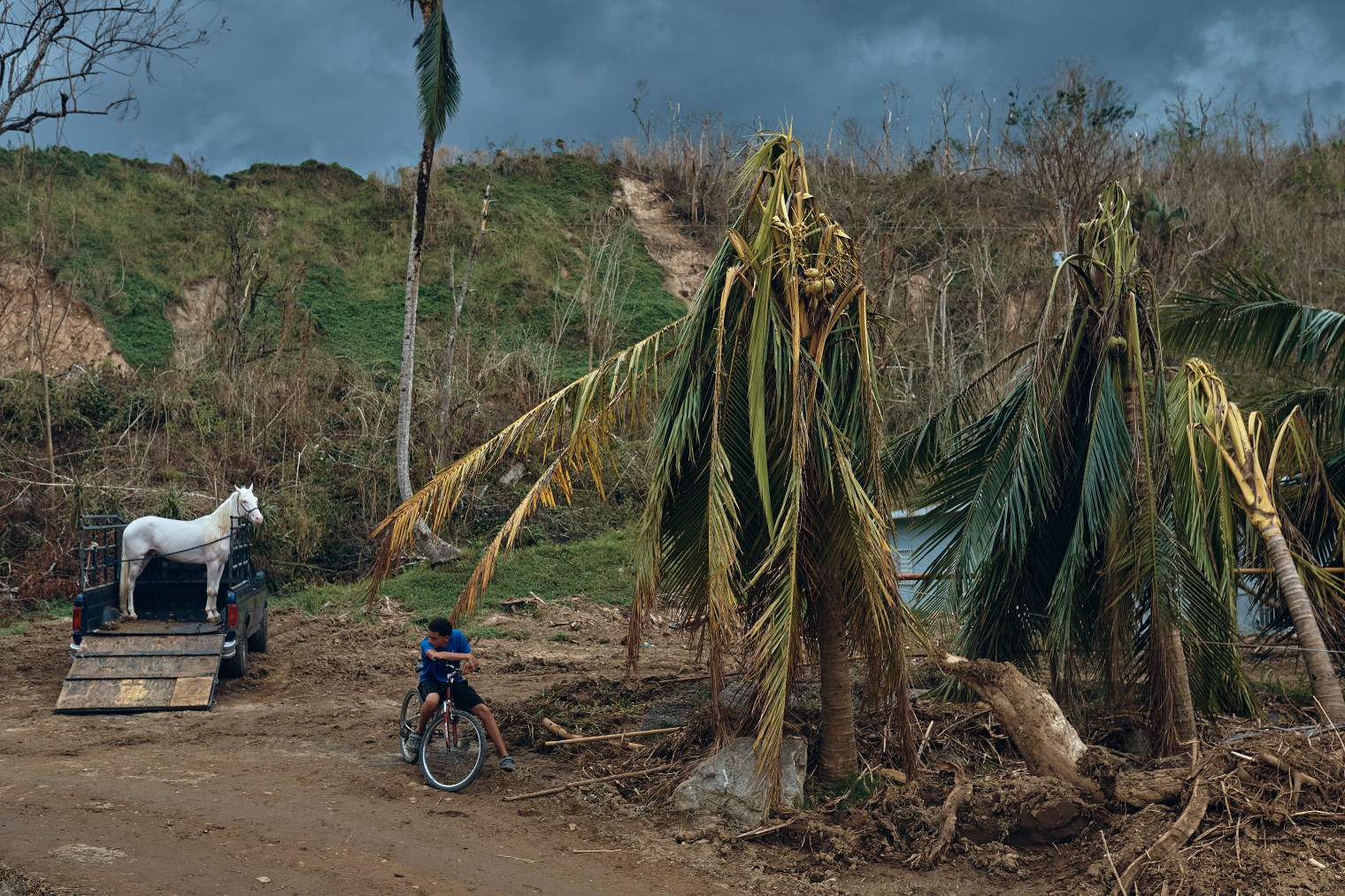 A man waits near a damaged bridge in Morovis, Puerto Rico, on Oct. 1, 2017.